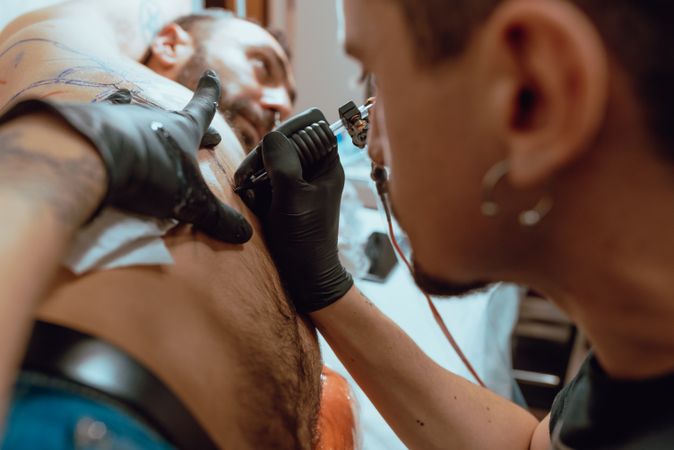 Stylish man receiving tattoo