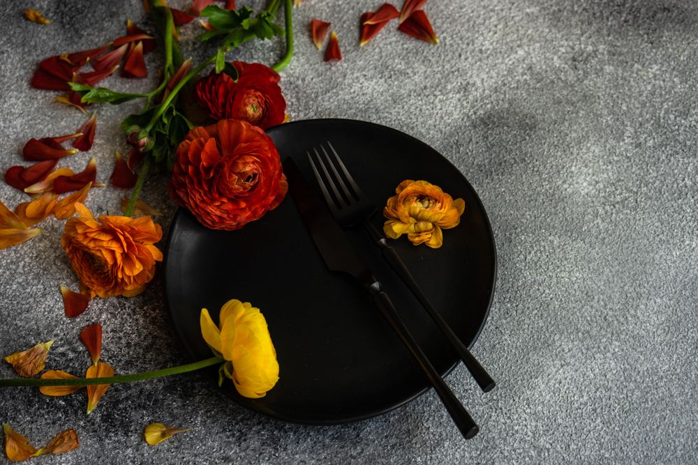 Rustic table setting with fresh red and yellow flowers