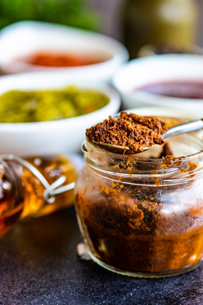 Pot of traditional Georgian adjika sauce with spoon