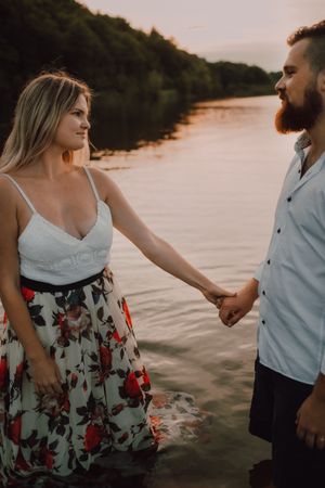 Loving couple standing ankle deep in water on beach
