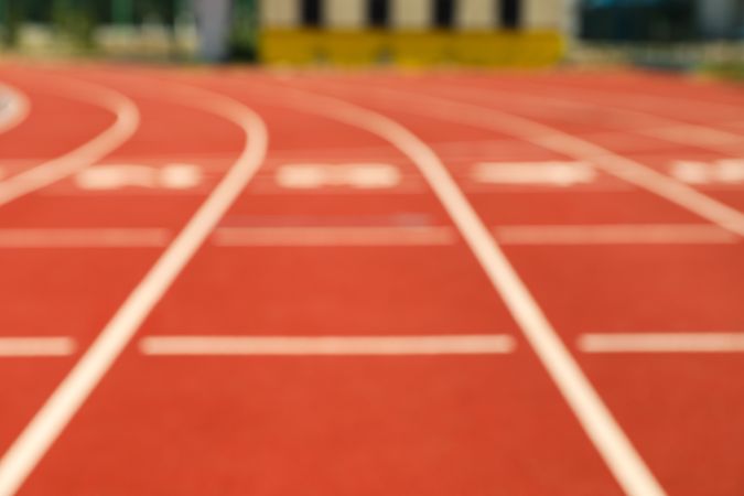 Start of red athletic track with numbers, blurred background