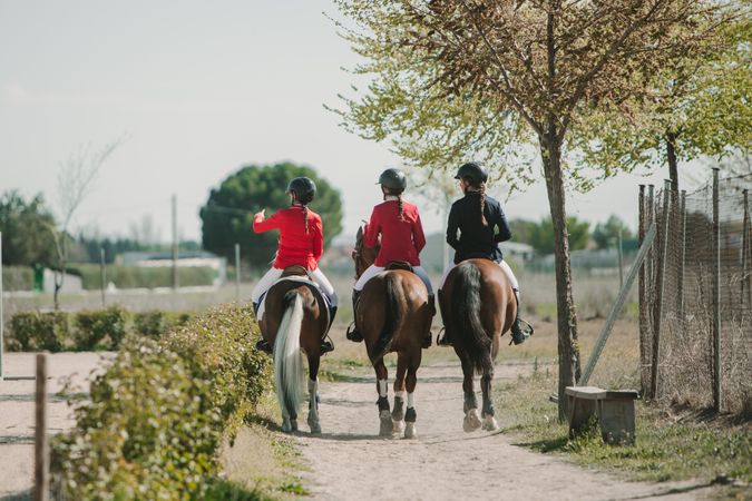 Young horse riders on pathway in nature