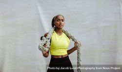 Confident athlete woman holding battling rope 4MYgq4