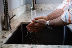 Close up cropped shot on man washing his hands with soap and water