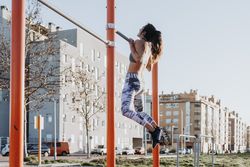 Woman training on parallel bars on street