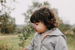 Girl smelling a flower outside