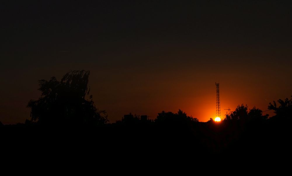 Red sun setting on dark morning