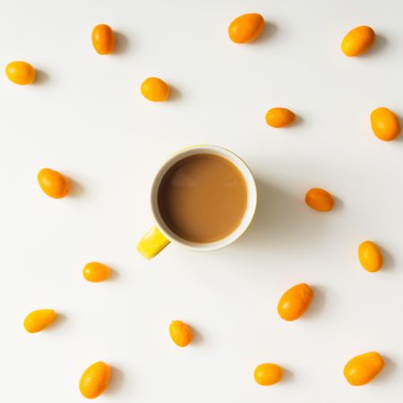 Pattern made of kumquats with coffee cup