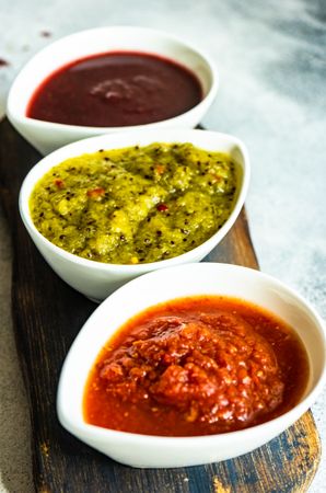 Three flavorful spicy traditional Georgian sauces on wooden board