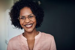 Portrait of smiling woman wearing glasses and pink shirt