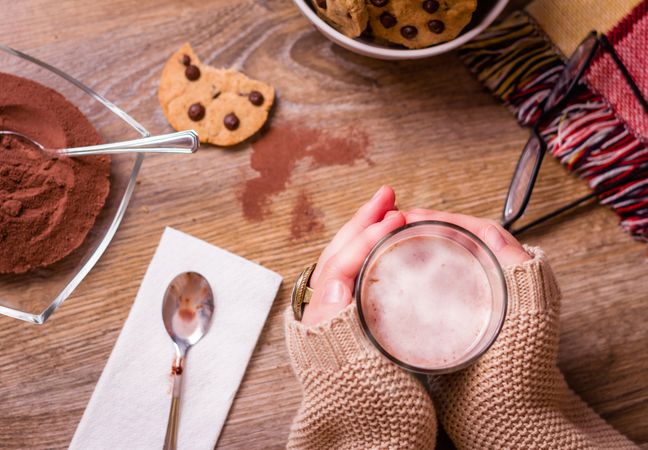 Female hands with hot drink and chocolate cookies