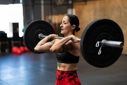Strong concentrated woman lifting weights in a gym