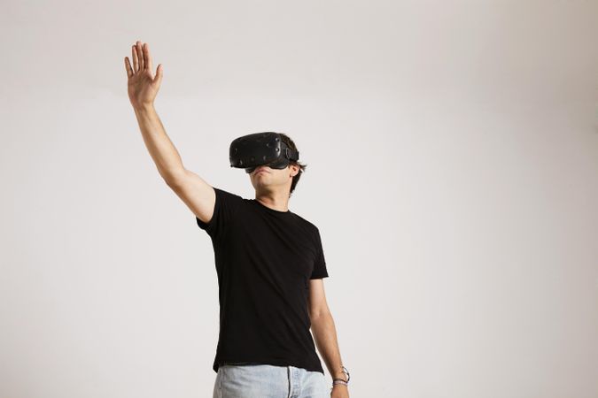 Man in VR headset with arm up