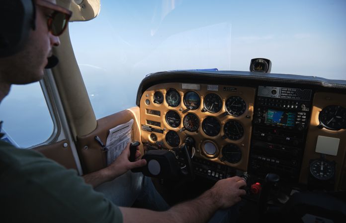 Crop focused pilot operating helicopter on clear day