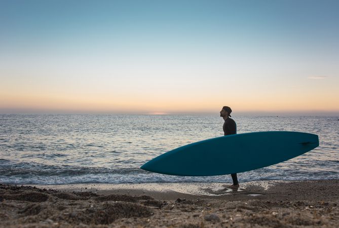 Man practicing paddle surfing with neoprene in a sunrise