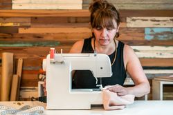 Fashion designer using sewing machine at her studio
