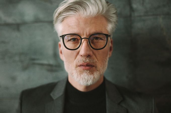 Close up portrait of businessman with white hair wearing glasses