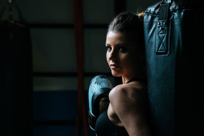 Sportswoman in boxing gloves in gym