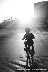 Grayscale photo of boy riding a bicycle 0KQED4