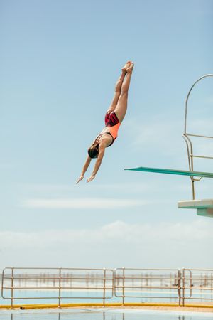 Woman diving into the pool from spring board