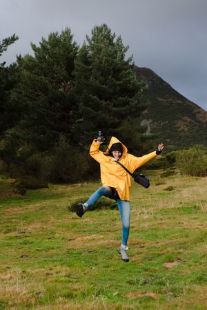 Person in yellow raincoat walking in forest
