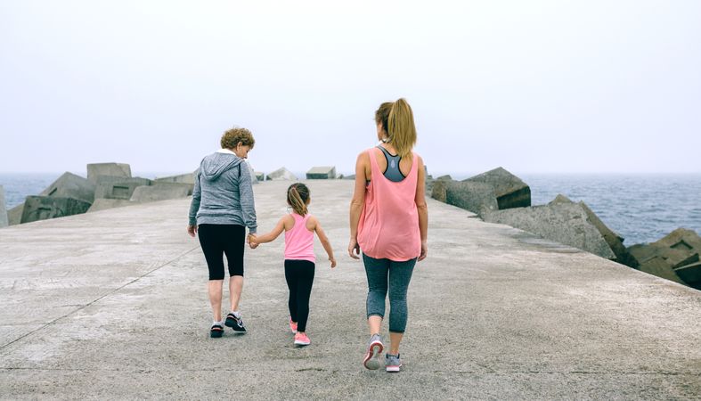 Back view of three female generations walking
