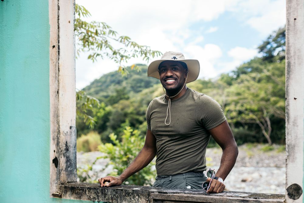 Black man wearing a hat at a window