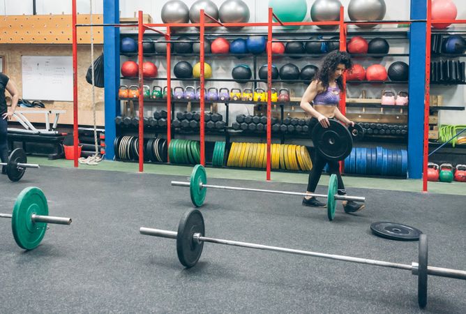 Woman picking up weightlifting discs