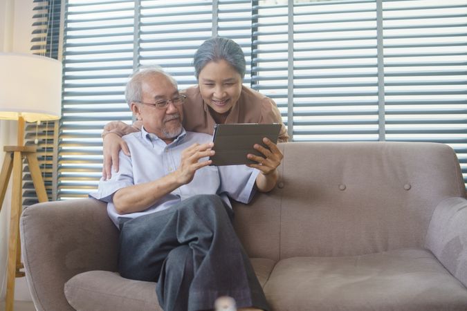 Older Asian couple watching or video call with family
