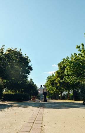 Couple walking and playing with their dog