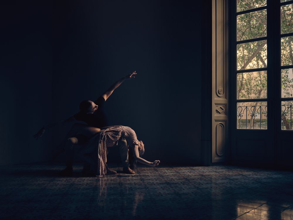 Flexible couple dancing ballet in dark room