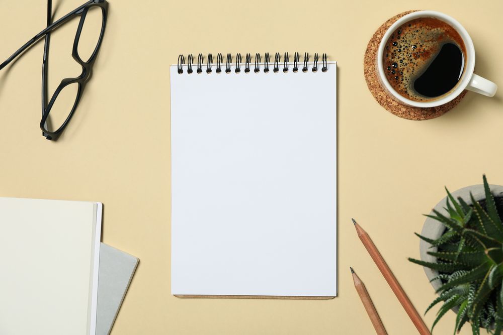 Office concept with blank notebook on beige background, space for text