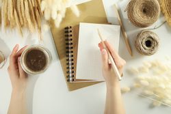 Looking down at woman writing in notebook