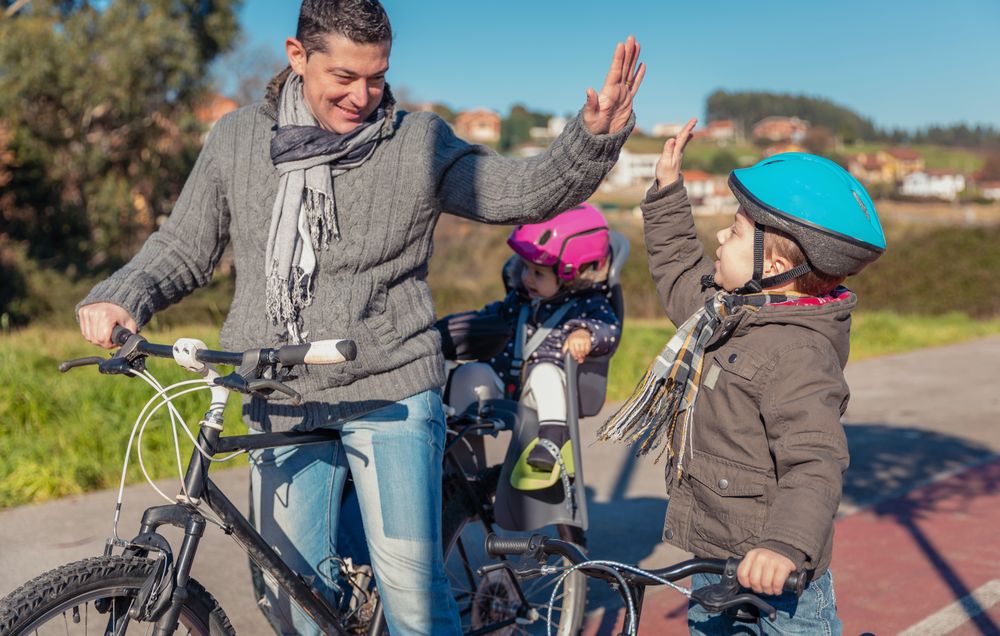 Father and son high fiving on family bike ride