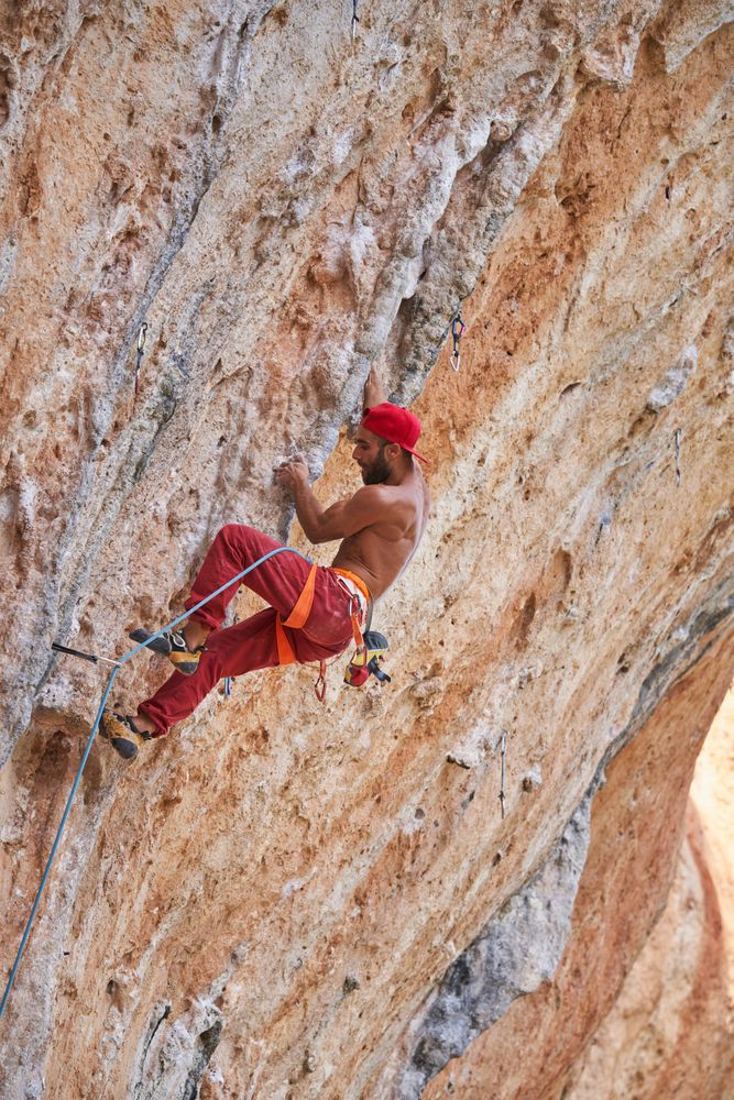 Climber ascending rocky mountain slope