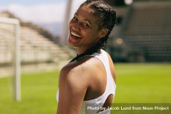 Close-up of a fit female athlete looking over her shoulder and smiling 47lJzb