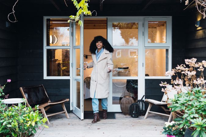 Happy Black woman standing in doorway of house