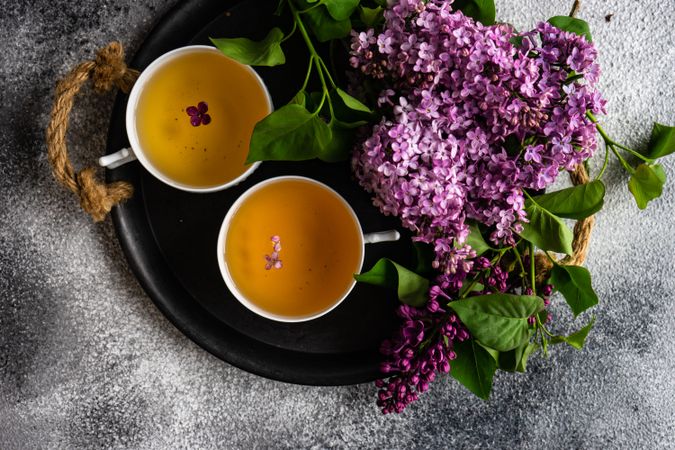 Top view of tray of tea with delicate tea and pink flowers