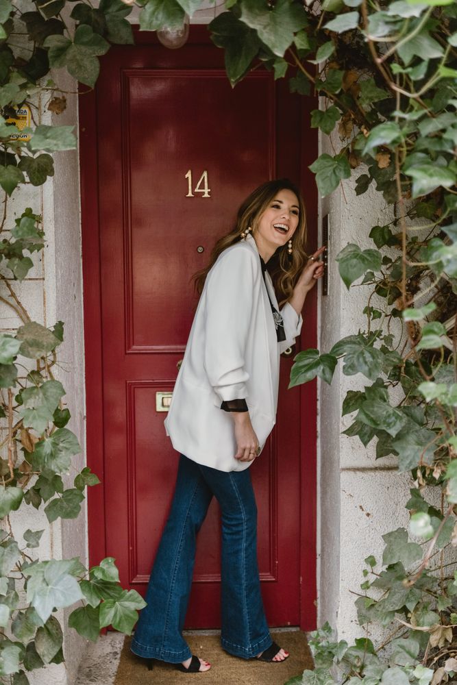 Stylish woman standing near red door