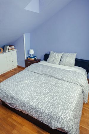 Bedroom in an attic with double bed with grey duvet