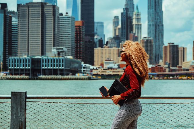 Smiling professional Black female looking at New York from Brooklyn