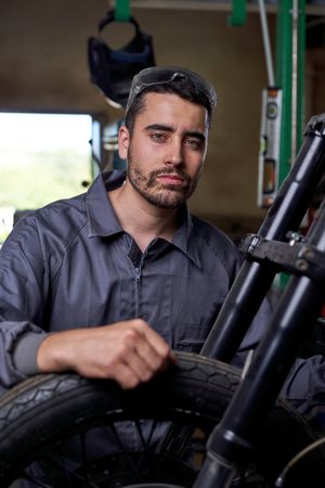 Male mechanic with motorbike in garage