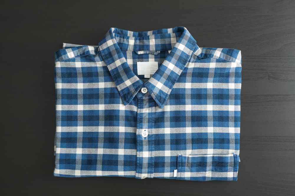 Folded checkered shirt on table, top view