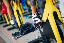 Group of people working out on stationary bikes at spinning class