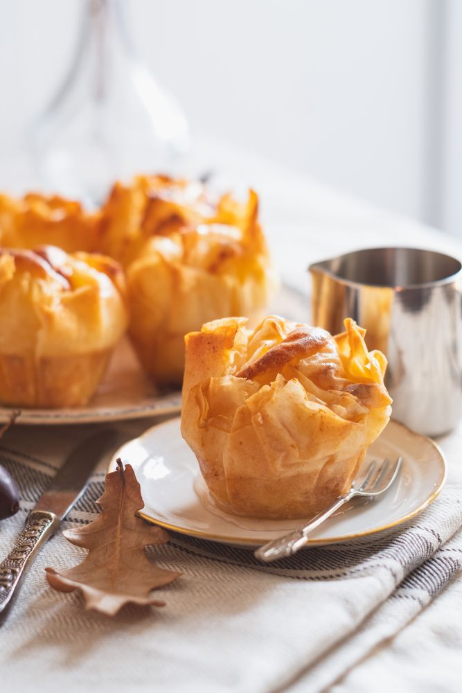 Galaktoboureko pastries on table with syrup dispenser