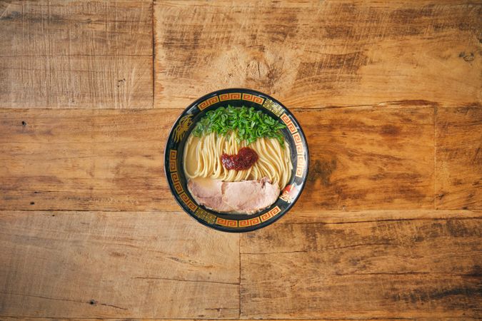 Tasty ramen with chopped green onions and tomato salsa