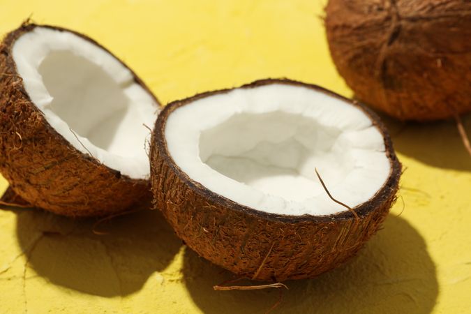 Coconut on yellow background, close up. Tropical fruit