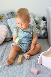Baby playing with toy blocks on bed in daytime