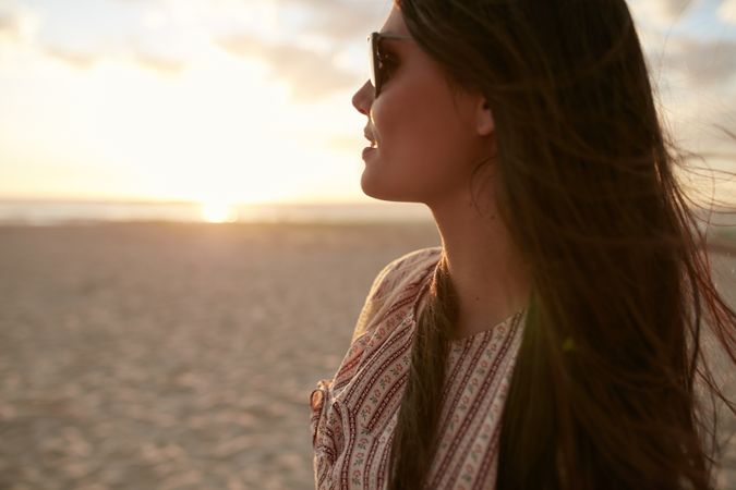 Close up shot of beautiful young woman with sunglasses looking away at a view