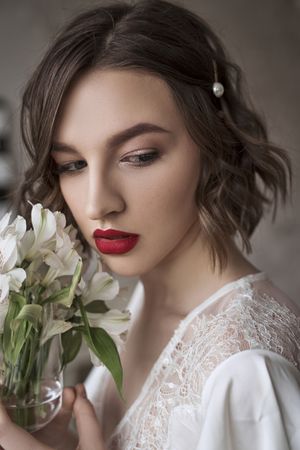 woman with red lips holding white flowers and dreaming